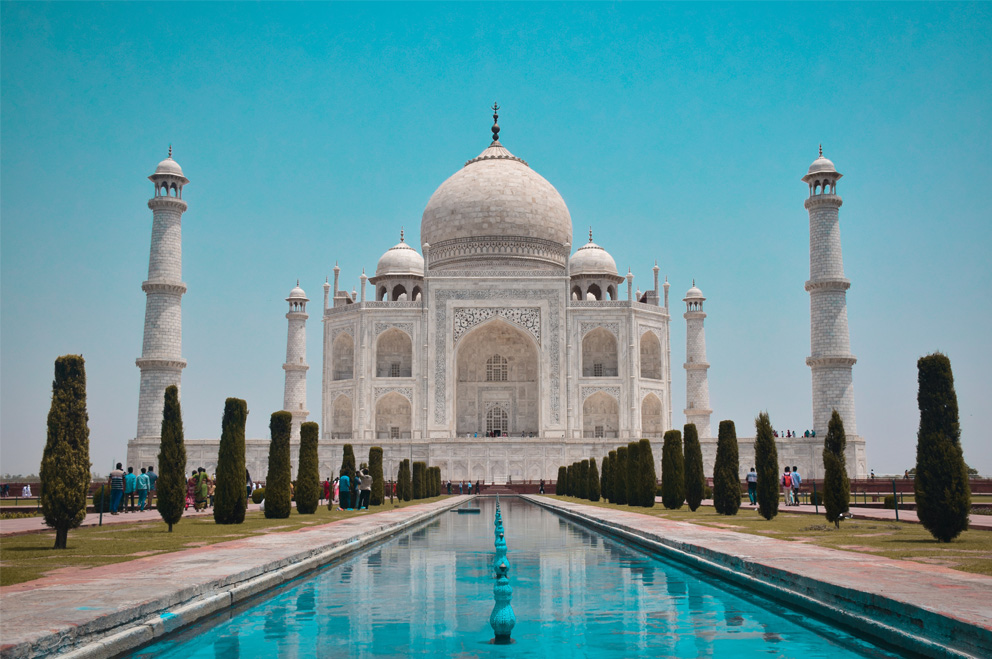 Im Bild zu sehen ist das Taj Mahal von vorne vor einem klaren, blauen Himmel. Das Taj Mahal ist eine Grabmoschee in Agra im indischen Bundesstaat Uttar Pradesh. Das imposante Bauwerk ist 58 Meter hoch und wurde auf einer 100x100 Meter großen Marmorplattform errichtet. Es befindet sich in Agra im indischen Bundesstaat Uttar Pradesh. 